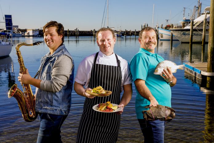 Newcastle saxophonist Liam Eastwell, Little Beach Boathouse head chef Ben Way and Nelson Bay Fish Market co-owner Darryn Hearn near D’Albora Marinas ahead of the Love Sea Food event