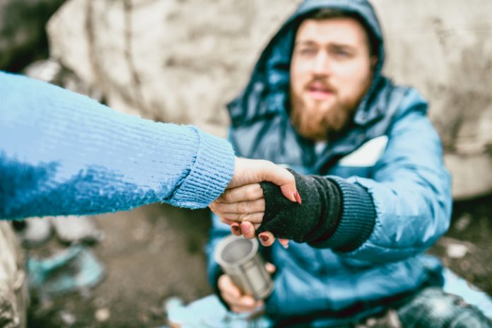 hand reaching out to help homeless man