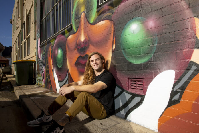Jordan Lucky Artist in front of his mural in Civic Lane, Newcastle