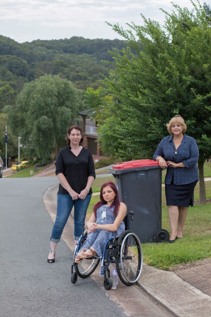 three women near a wheelie bin