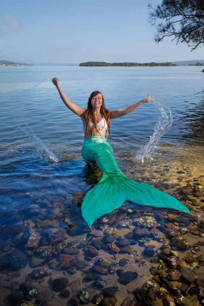 woman dressed as mermaid in shallow water