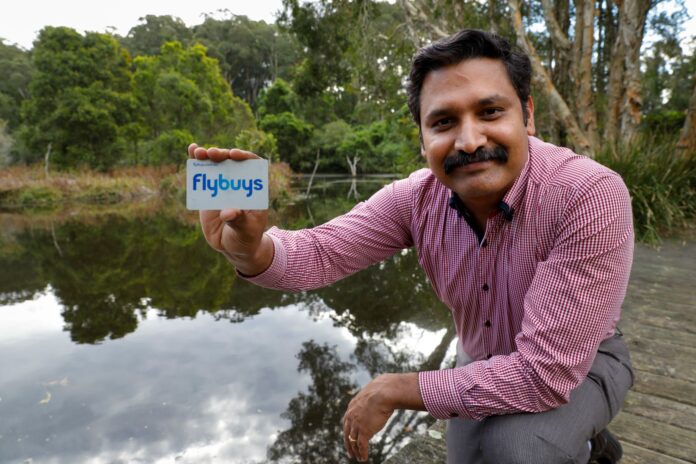 man holding flybuys card near lake