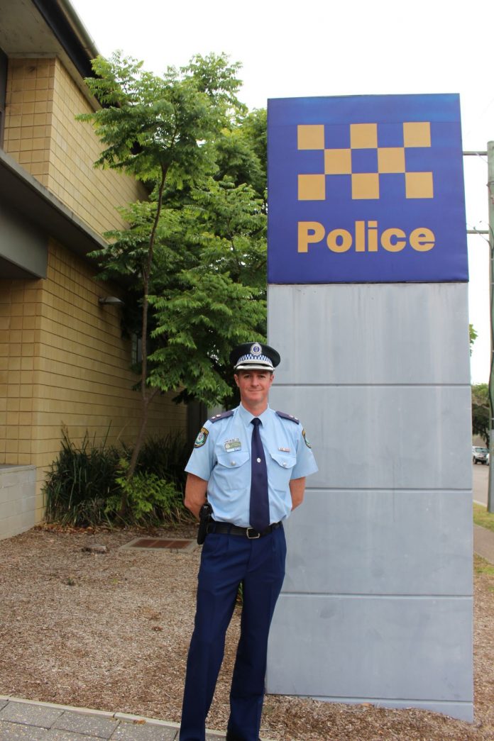 Policeholidaysafety (1) police officer in front of police sign