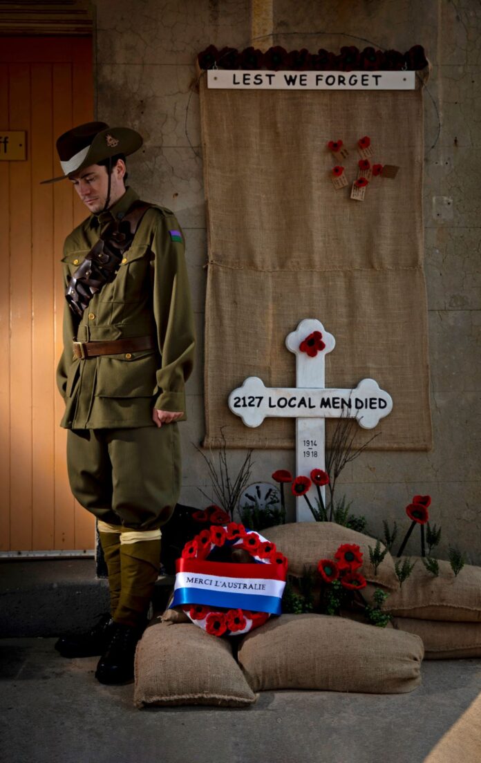 Fort Scratchley Gun Crew member, Lachlan Curryer, with the Lest we Forget Banner of Remembrance.