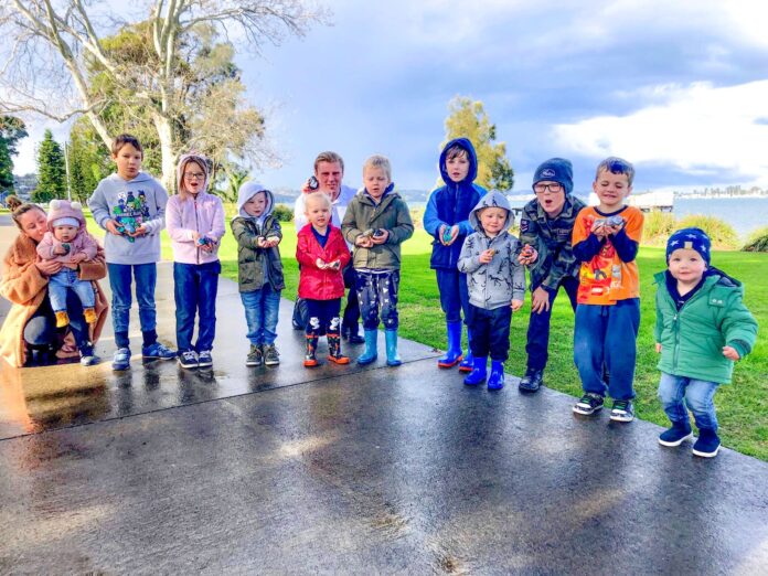 Children gather at Speers Point Park with painted rocks they’ve discovered.