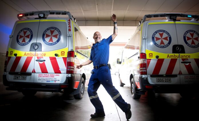 man in front of two ambulances