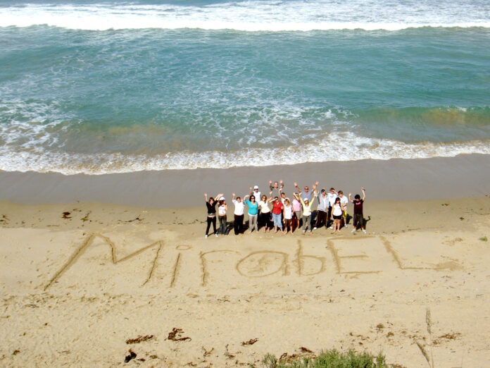 people on the beach with 'mirabel' written in sand