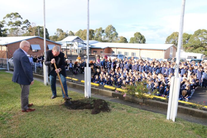 Stephen Vidot and Graham Pritchard dig up the time capsule as the St Paul’s Primary School body watches on.