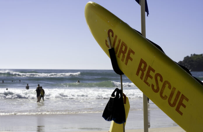Lifesaving board and swimmers at the beach.