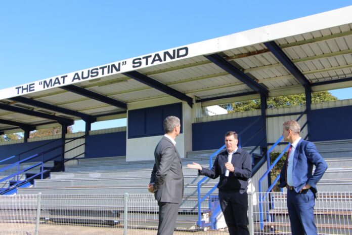 three men in front of the mat austin stand