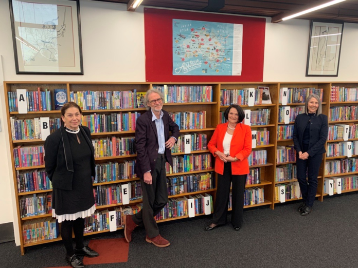 people standing in front of books at a library