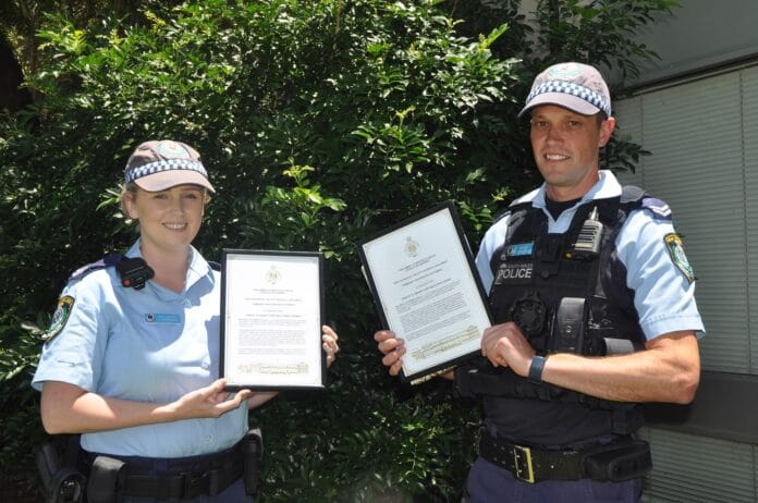 two police officers holding awards