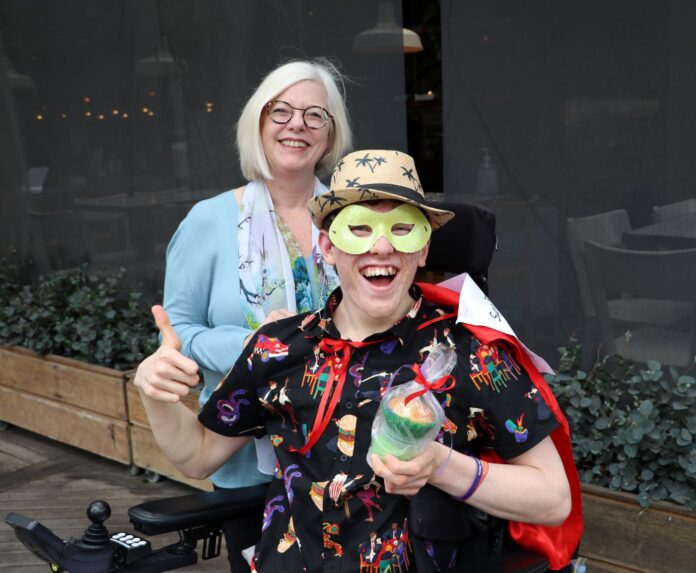 male in wheelchair holding a cupcake