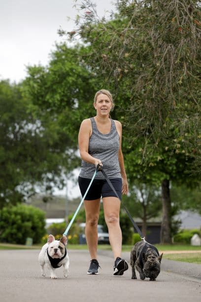 woman walking her two dogs