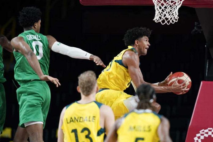 Australia's Matisse Thybulle drives to the basket past Nigeria's Chikezie Okpala, left, during a men's basketball preliminary round game at the 2020 Summer Olympics