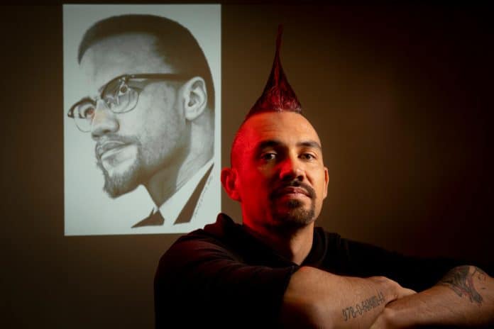 Damien Linnane with his drawing of Malcolm X