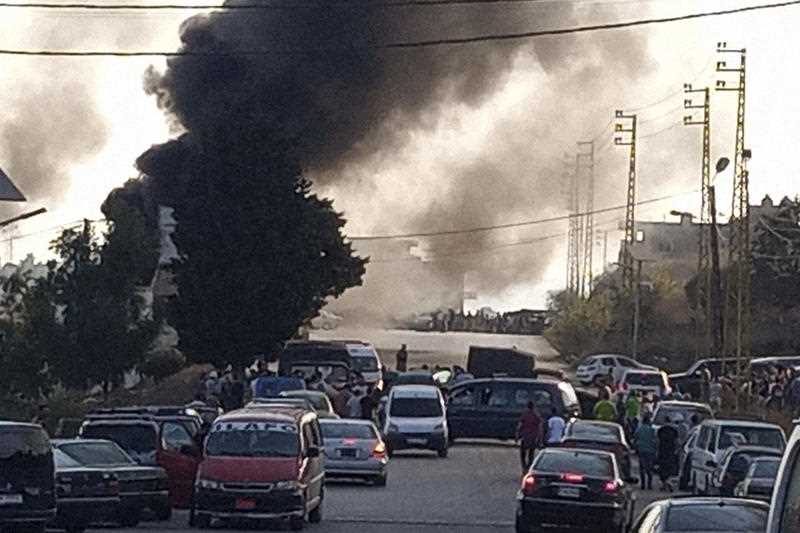 Black smoke rises from the scene where a fuel tanker exploded, in Tleil village, north Lebanon, Sunday, Aug. 15, 2021