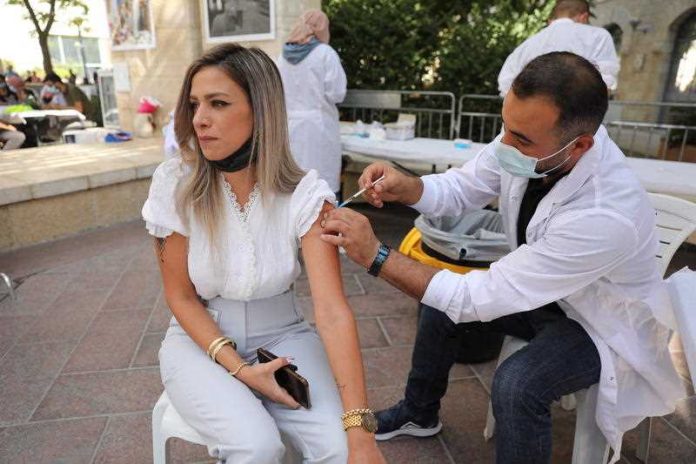 A nurse injects a women with a third shot of COVID-19 vaccine in Jerusalem, Israel,
