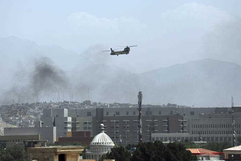 A U.S. Chinook helicopter flies over the city of Kabul, Afghanistan, Sunday, Aug. 15, 2021 as Taliban fighters enter the outskirts of the Afghan capital