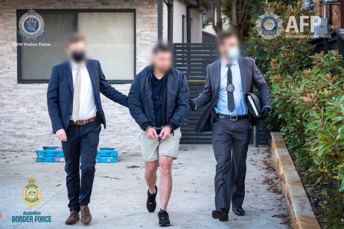 Two plain clothes police men arrest a 29-year-old Sydney man who has been charged in connection to Australia’s largest heroin seizure in almost two decades, with the drugs worth about $156 million.