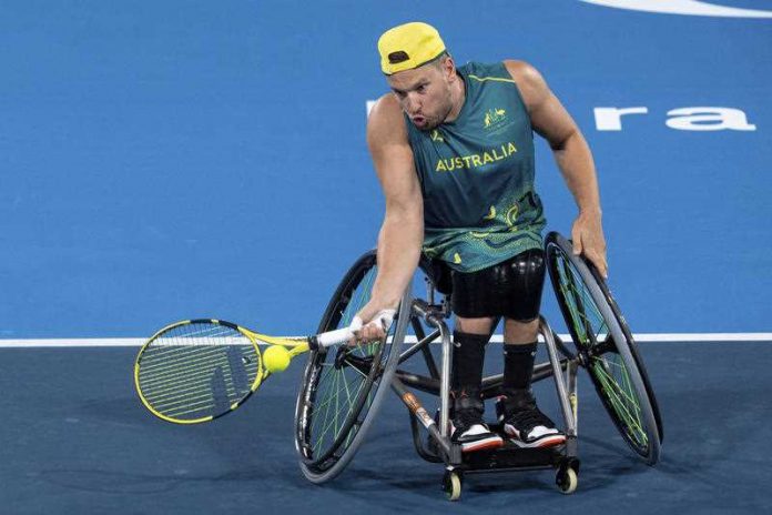 Australian Paralympian Dylan Alcott in green and gold tennis outfit playing wheelchair tennis