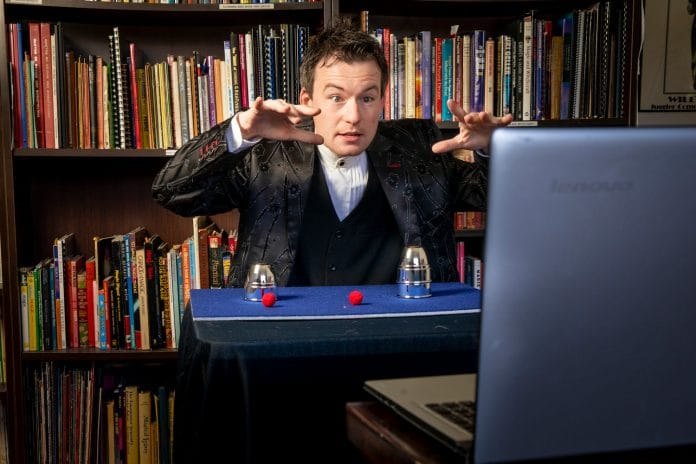 Joel Howlett performing a magic trick during a video call