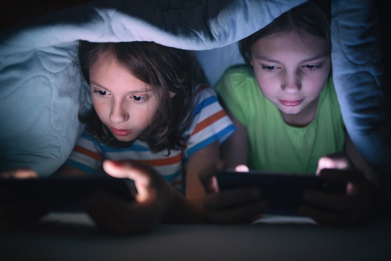 Two children using mobile devices