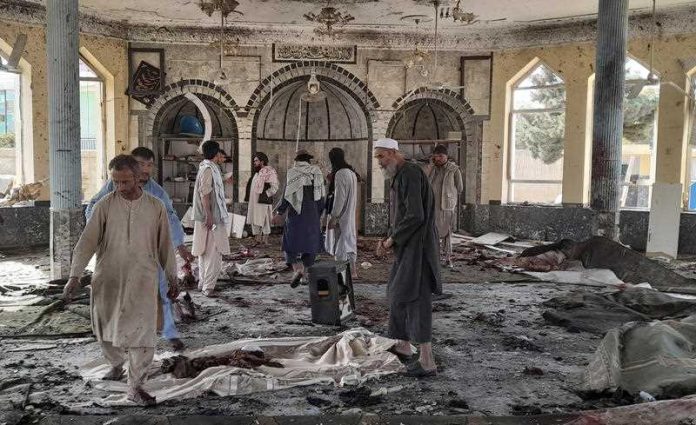 People view the damage inside of a mosque following a bombing in Kunduz, province northern Afghanistan, Friday, Oct. 8, 2021