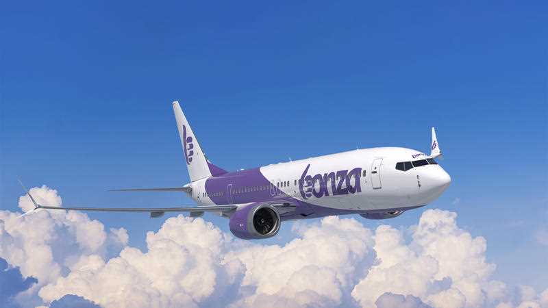 Bonza Airline's new Boeing 737-8 Bonza aircraft in purple and white livery is seen flying above the clouds