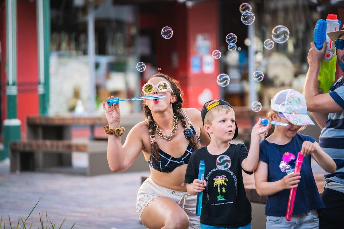 A woman and children blowing bubbles at The Levee