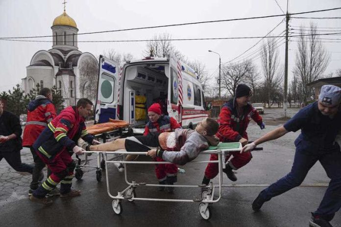 Ambulance paramedics move an injured man on a stretcher, wounded by shelling in a residential area in Mariupol, Ukraine