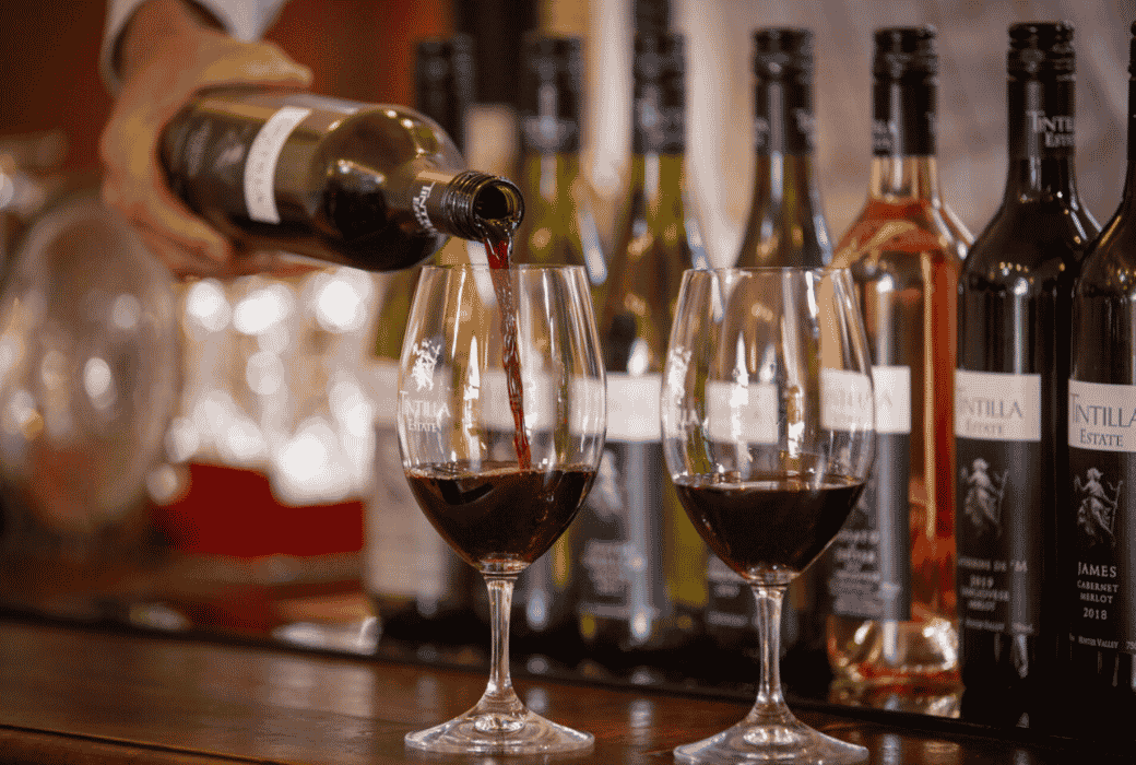 Red wine being poured into a wine glass at an Tintilla Estate tasting table during the D'Vine Festival in the Hunter Valley