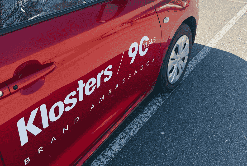 red suzuki swift with klosters branding.